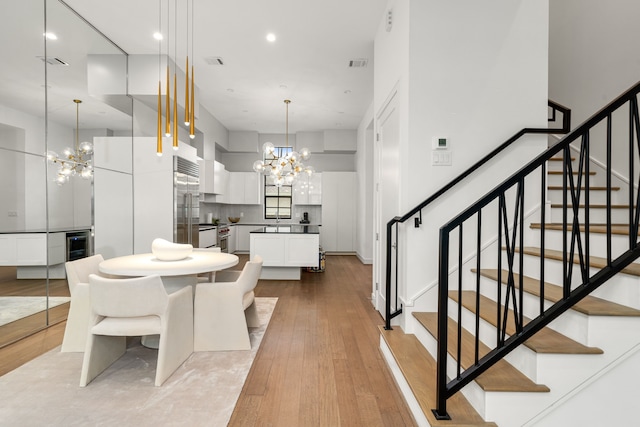 5820 Winsome Ln Unit B, Houston, TX 77057 - dining area featuring a chandelier, wood finished floors, stairs, wine cooler, and recessed lighting
