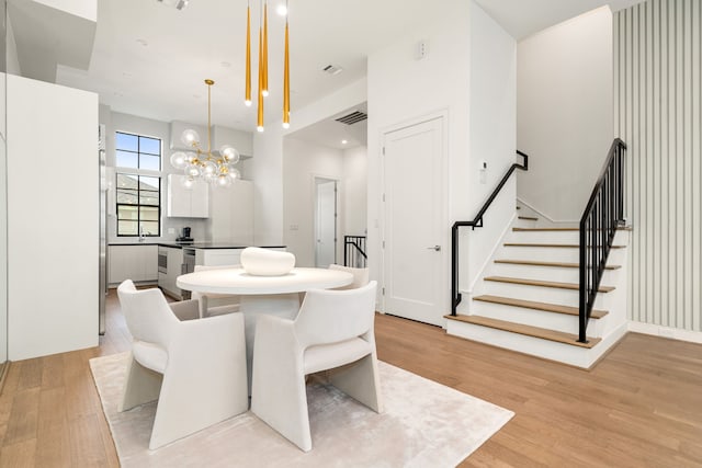 5820 Winsome Ln Unit B, Houston, TX 77057 - dining room featuring light wood-style flooring, stairs, and a chandelier
