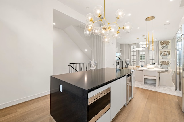 5820 Winsome Ln Unit B, Houston, TX 77057 - kitchen with dark countertops, light wood-style flooring, stainless steel microwave, white cabinets, and recessed lighting