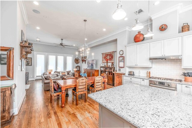 2110 Mason St, Houston, TX 77006 - kitchen featuring oven, ornamental molding, a ceiling fan, under cabinet range hood, and backsplash