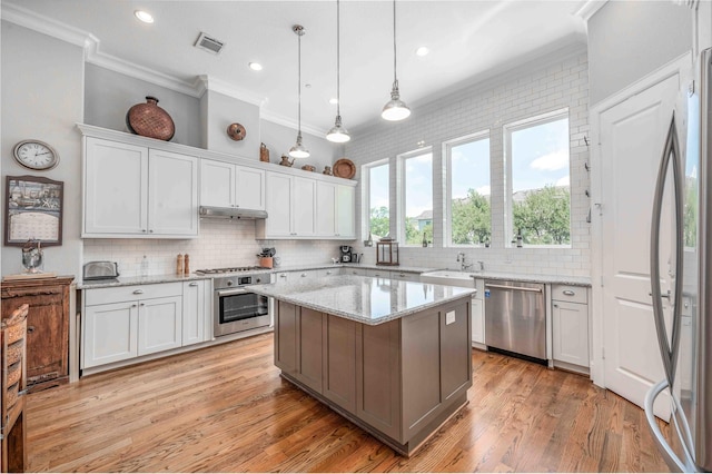2110 Mason St, Houston, TX 77006 - kitchen with appliances with stainless steel finishes, ornamental molding, white cabinetry, tasteful backsplash, and a sink