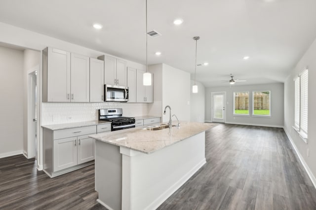 18717 Bliss Pl, New Caney, TX 77357 - kitchen featuring appliances with stainless steel finishes, a sink, decorative backsplash, dark wood finished floors, and baseboards