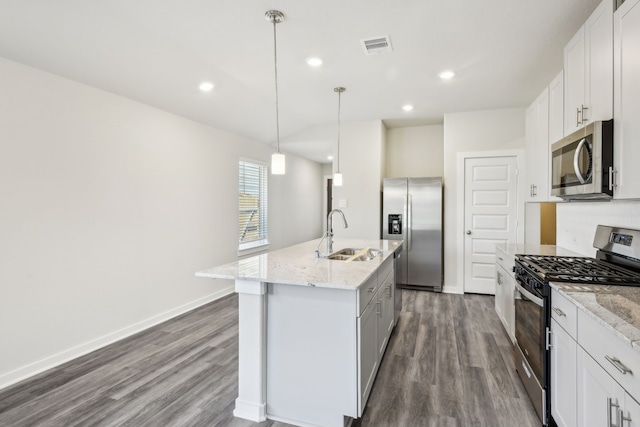18717 Bliss Pl, New Caney, TX 77357 - kitchen with stainless steel appliances, a sink, dark wood-type flooring, a kitchen island with sink, and recessed lighting