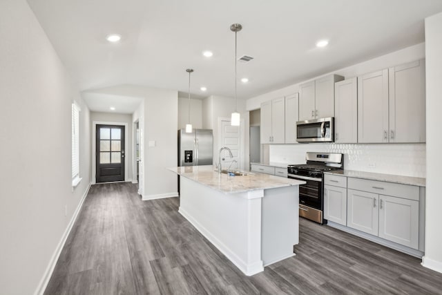 18717 Bliss Pl, New Caney, TX 77357 - kitchen featuring stainless steel appliances, a sink, decorative backsplash, dark wood-type flooring, and a kitchen island with sink