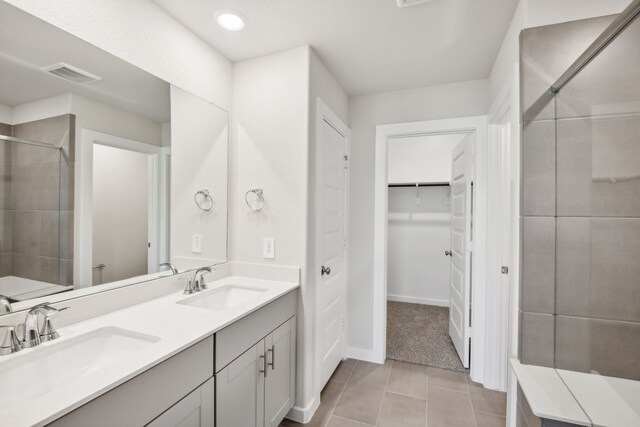 18717 Bliss Pl, New Caney, TX 77357 - full bath featuring a shower stall, double vanity, a walk in closet, tile patterned flooring, and baseboards