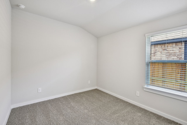 18717 Bliss Pl, New Caney, TX 77357 - empty room featuring carpet floors, vaulted ceiling, healthy amount of natural light, and baseboards