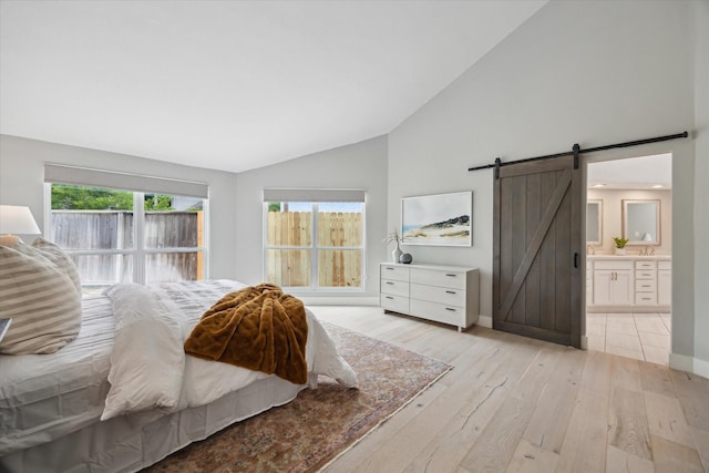 625 Rancho Bauer Dr, Houston, TX 77079 - bedroom with a barn door, light wood-type flooring, baseboards, high vaulted ceiling, and ensuite bathroom