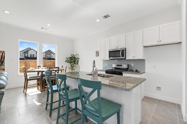 6414 Pregonero Ln, Houston, TX 77048 - kitchen featuring stainless steel appliances, a sink, light stone countertops, decorative backsplash, and baseboards