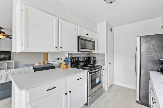 2219 Anthony Hay Ln, Katy, TX 77449 - kitchen featuring stainless steel appliances, white cabinets, light countertops, ceiling fan, and light tile patterned floors