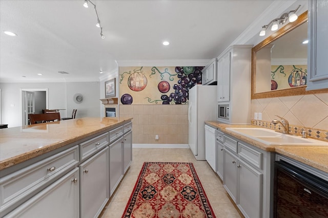 37922 Clubhouse Ln, Magnolia, TX 77355 - kitchen with a sink, ornamental molding, white appliances, tile walls, and light tile patterned floors