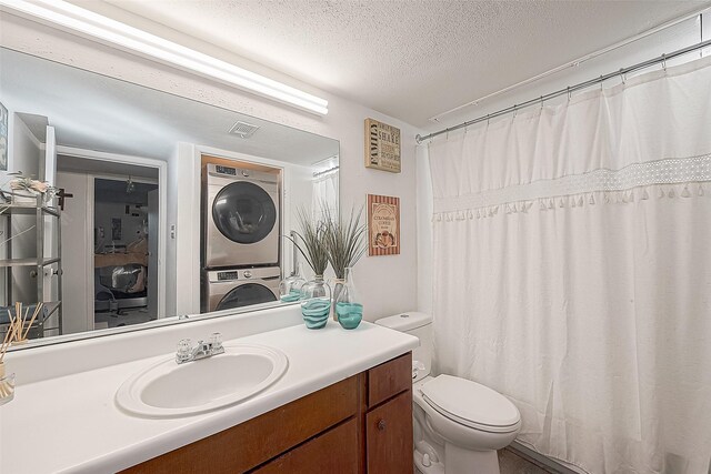 3075 Walnut Bend Ln Unit 28, Houston, TX 77042 - bathroom with stacked washer and clothes dryer, toilet, vanity, and a textured ceiling
