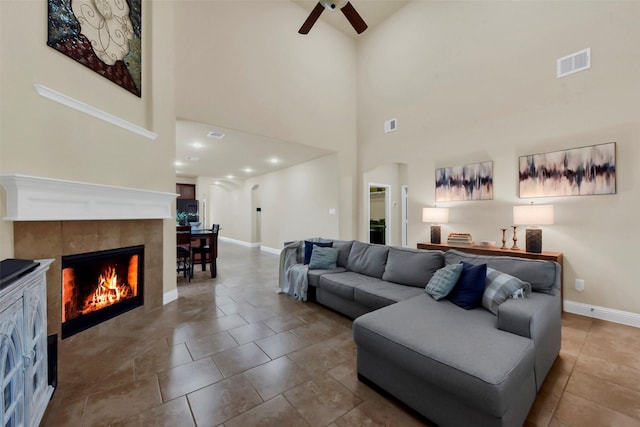 6 Muthill Cir, Conroe, TX 77304 - living room featuring ceiling fan, baseboards, a high ceiling, a tile fireplace, and tile patterned floors