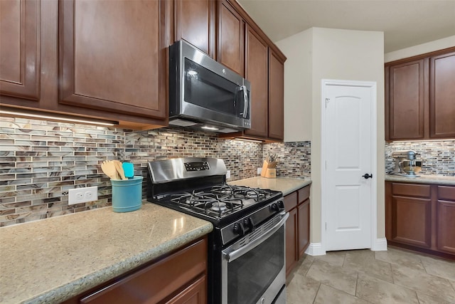 6 Muthill Cir, Conroe, TX 77304 - kitchen with stainless steel appliances, backsplash, and light stone countertops