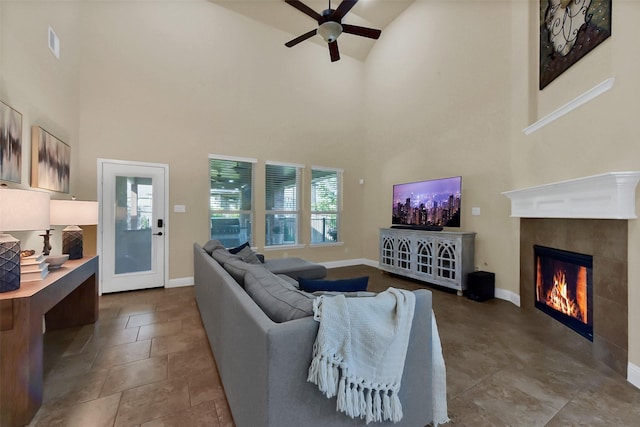 6 Muthill Cir, Conroe, TX 77304 - living area with a tiled fireplace, a ceiling fan, a towering ceiling, and baseboards