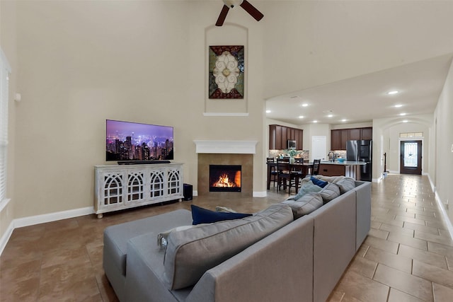 6 Muthill Cir, Conroe, TX 77304 - tiled living room featuring ceiling fan, a high ceiling, a tile fireplace, baseboards, and recessed lighting