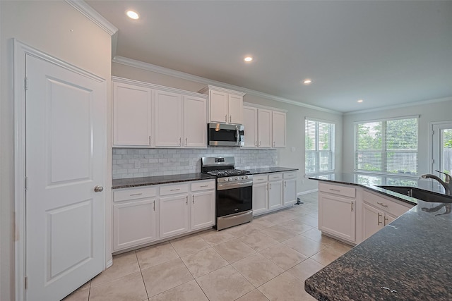 2822 Bluesage Bluff Dr, Richmond, TX 77406 - kitchen with stainless steel appliances, a sink, crown molding, tasteful backsplash, and white cabinets