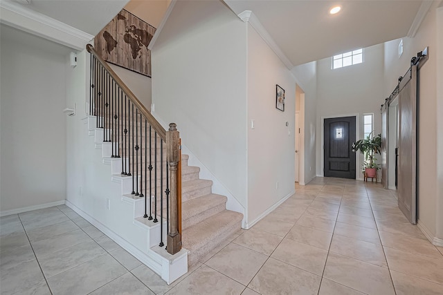 2822 Bluesage Bluff Dr, Richmond, TX 77406 - foyer entrance featuring stairs, a barn door, light tile patterned flooring, baseboards, and crown molding
