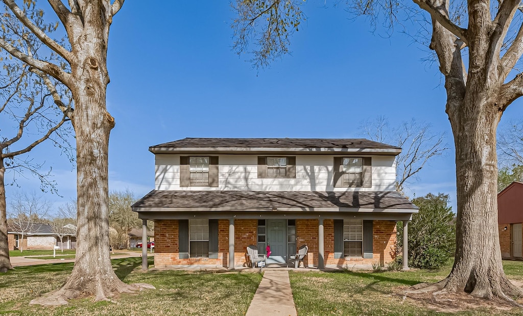 3803 Quail Meadow Dr, Missouri City, TX 77459 - view of front of home featuring covered porch, brick siding, a front yard, and a shingled roof