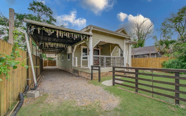 2711 Maury St, Houston, TX 77009 - view of front of home with a fenced backyard, gravel driveway, an attached carport, and covered porch
