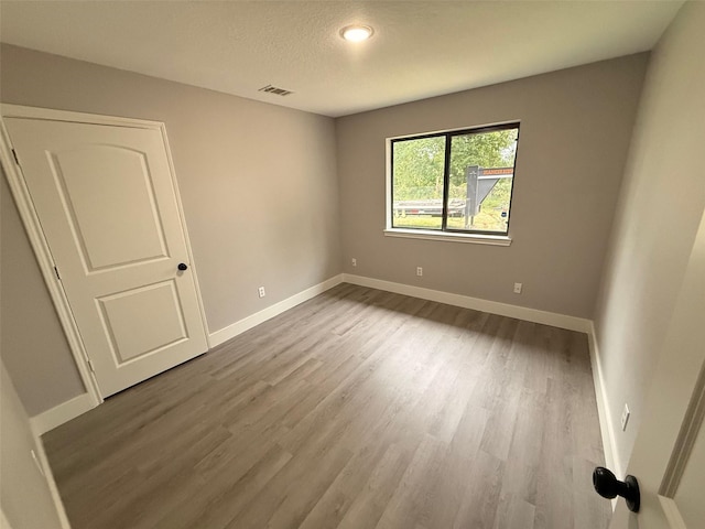 23711 Saxon Way, Hockley, TX 77447 - unfurnished room with wood finished floors, baseboards, and a textured ceiling