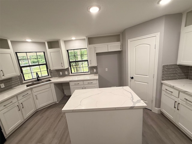 23711 Saxon Way, Hockley, TX 77447 - kitchen featuring a sink, backsplash, white cabinets, wood finished floors, and a kitchen island