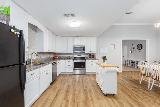 240 7th St, Trinity, TX 75862 - kitchen with appliances with stainless steel finishes, a sink, white cabinetry, light wood-type flooring, and ornamental molding
