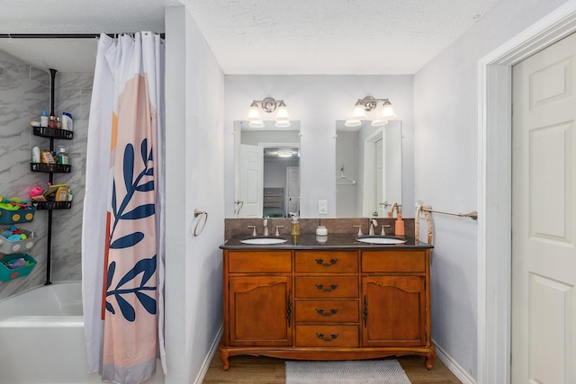 240 7th St, Trinity, TX 75862 - full bathroom with double vanity, wood finished floors, baseboards, and a textured ceiling