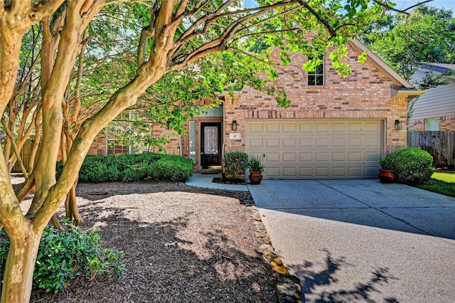 traditional home with brick siding, concrete driveway, and fence