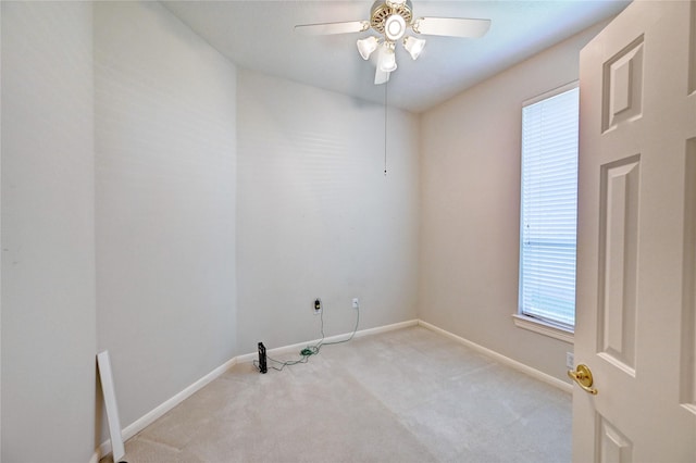 empty room featuring light carpet, a ceiling fan, and baseboards