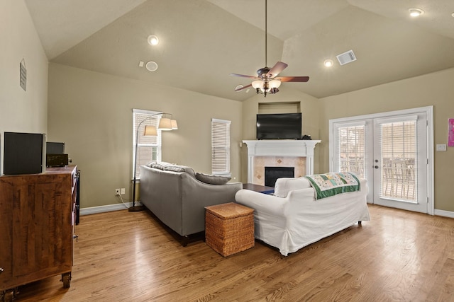 4609 Sharman St, Houston, TX 77009 - living area with lofted ceiling, a ceiling fan, light wood-style flooring, a tiled fireplace, and baseboards