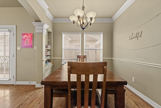 4609 Sharman St, Houston, TX 77009 - dining room featuring a chandelier, light wood finished floors, crown molding, arched walkways, and baseboards