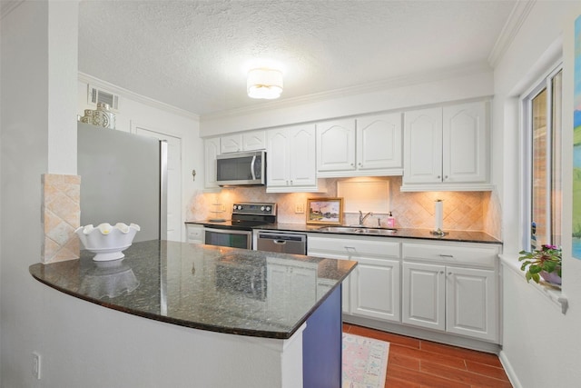 6475 Burgoyne Rd Unit 38, Houston, TX 77057 - kitchen featuring stainless steel appliances, a sink, wood finished floors, white cabinets, and crown molding