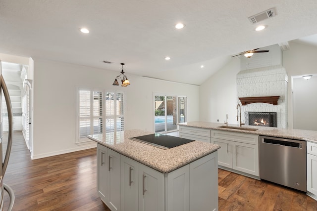 11623 Aspenway Dr, Houston, TX 77070 - kitchen with stainless steel dishwasher, a sink, black electric cooktop, a kitchen island, and a brick fireplace