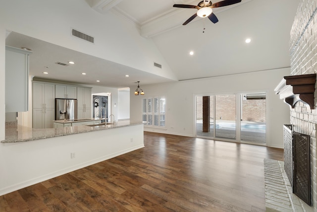 11623 Aspenway Dr, Houston, TX 77070 - unfurnished living room featuring high vaulted ceiling, beam ceiling, a brick fireplace, ceiling fan, and dark wood-style flooring