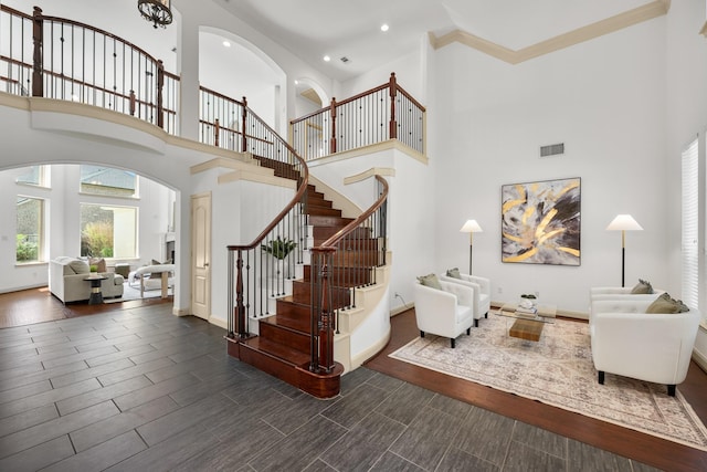 4603 Red Hawk Ct, Sugar Land, TX 77479 - staircase featuring a towering ceiling, arched walkways, wood tiled floors, recessed lighting, and baseboards