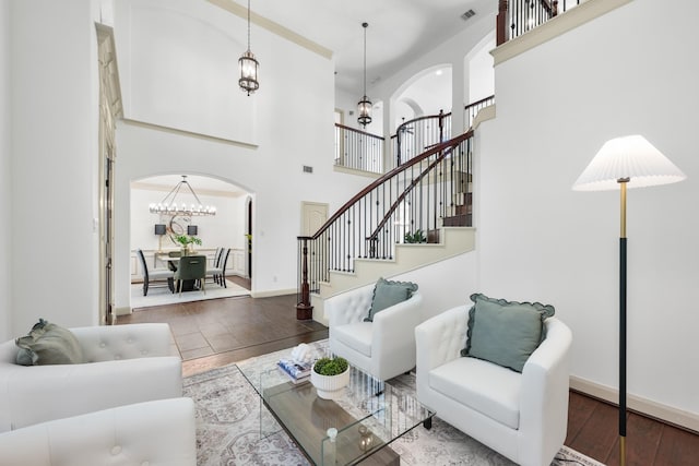 4603 Red Hawk Ct, Sugar Land, TX 77479 - living room with arched walkways, hardwood / wood-style floors, a towering ceiling, a chandelier, and baseboards