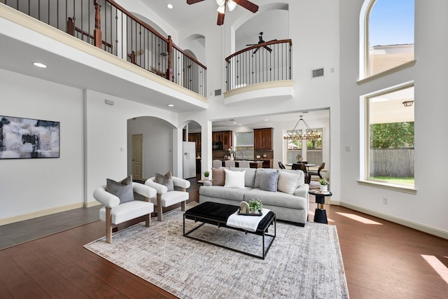 4603 Red Hawk Ct, Sugar Land, TX 77479 - living area with ceiling fan, dark wood-type flooring, arched walkways, a high ceiling, and baseboards