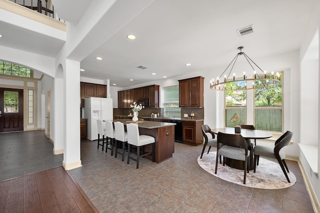 4603 Red Hawk Ct, Sugar Land, TX 77479 - kitchen with black appliances, a chandelier, a kitchen breakfast bar, a kitchen island, and decorative backsplash