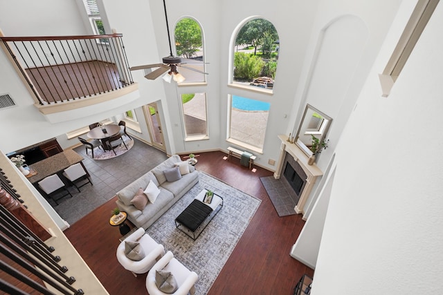 4603 Red Hawk Ct, Sugar Land, TX 77479 - living area featuring a towering ceiling, plenty of natural light, a ceiling fan, a fireplace with flush hearth, and wood finished floors