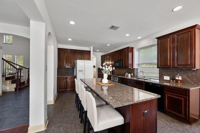 4603 Red Hawk Ct, Sugar Land, TX 77479 - kitchen with black appliances, a sink, recessed lighting, arched walkways, and tasteful backsplash