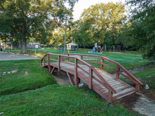 surrounding community with a lawn and view of wooded area