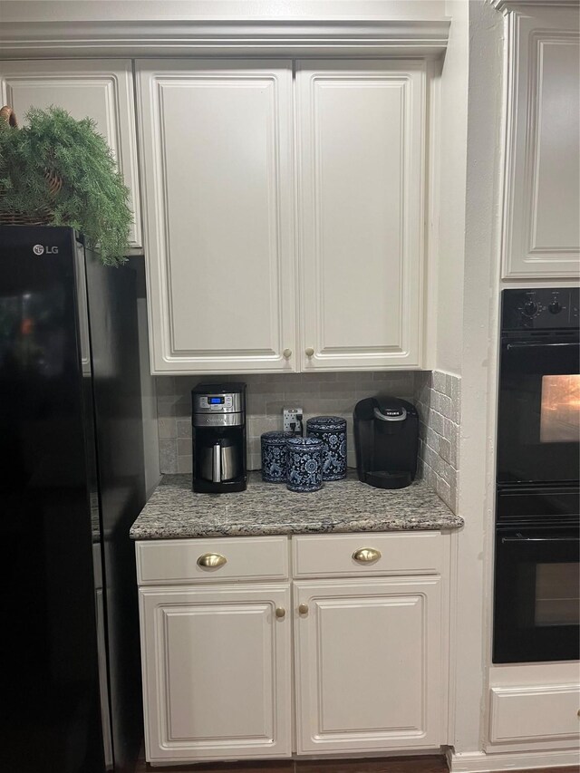 2103 Crescent Coral Dr, League City, TX 77573 - kitchen featuring black appliances, white cabinets, light stone countertops, and backsplash