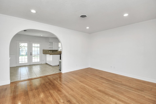 2606 Droxford Dr, Houston, TX 77008 - empty room with arched walkways, light wood-type flooring, baseboards, ornamental molding, and recessed lighting