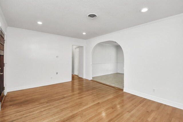 2606 Droxford Dr, Houston, TX 77008 - unfurnished room with arched walkways, light wood-style floors, ornamental molding, recessed lighting, and baseboards