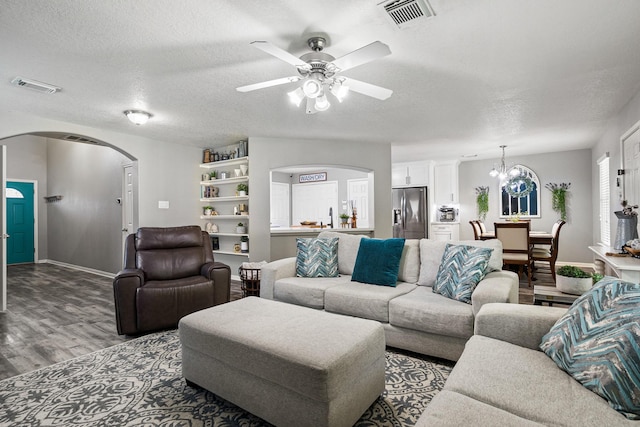 2023 Briar Grove Dr, Conroe, TX 77301 - living room with arched walkways, wood finished floors, a textured ceiling, ceiling fan, and a chandelier