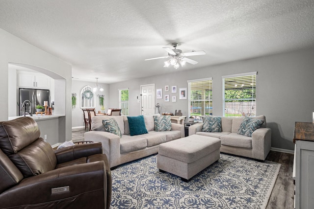 2023 Briar Grove Dr, Conroe, TX 77301 - living room featuring wood finished floors, baseboards, ceiling fan, a textured ceiling, and arched walkways