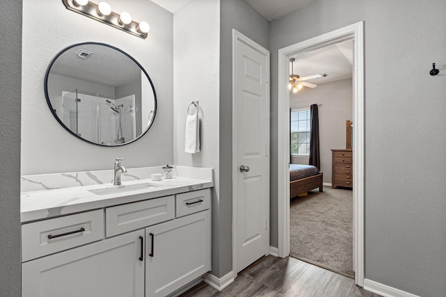 2023 Briar Grove Dr, Conroe, TX 77301 - bathroom featuring wood finished floors, ceiling fan, vanity, baseboards, and a shower
