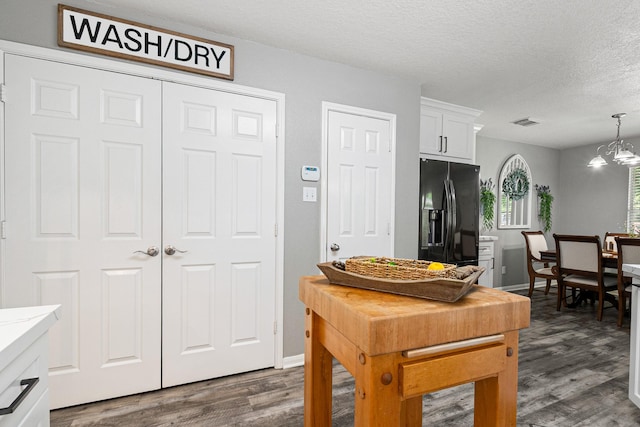 2023 Briar Grove Dr, Conroe, TX 77301 - kitchen featuring black fridge, dark wood-style floors, white cabinets, a textured ceiling, and decorative light fixtures