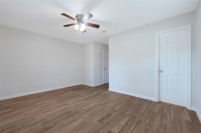 empty room featuring wood finished floors, a ceiling fan, and baseboards