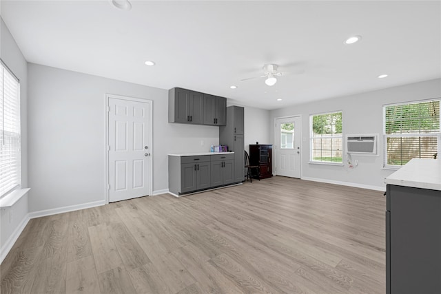 kitchen with gray cabinetry, a ceiling fan, light countertops, light wood-style floors, and baseboards